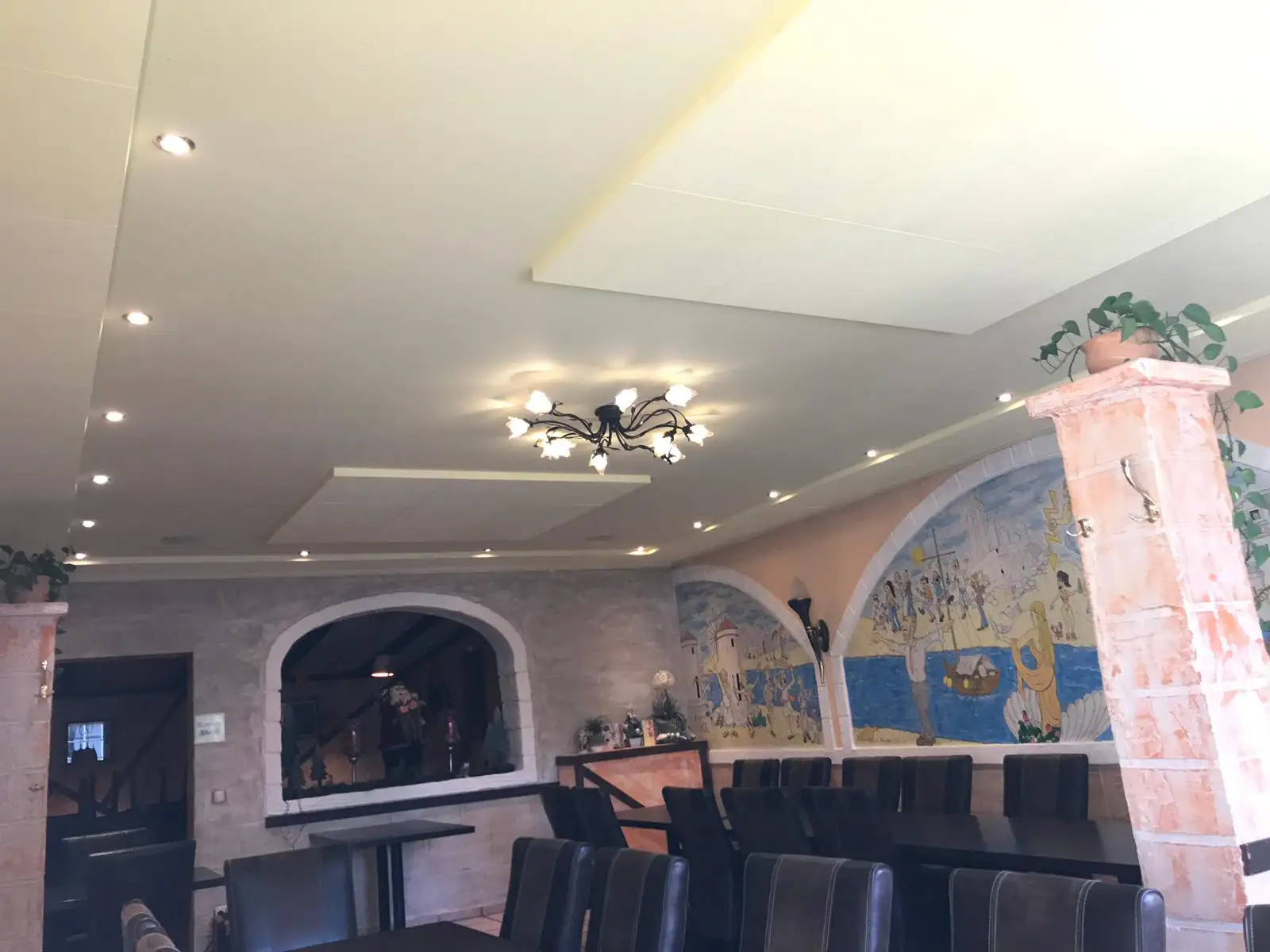 Cremefarbene Akustikpaneele passgenau um Beleuchtung und Formteile montiert in einer Taverne in Irxleben