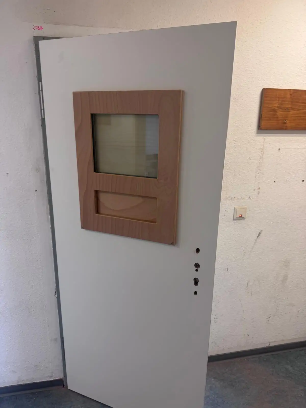 Geöffnete Sicherheitstür mit eingebautem Sichtfenster und Durchreiche-Klappe zum Schutz von Mitarbeitenden in einer Verwaltungseinrichtung in Magdeburg