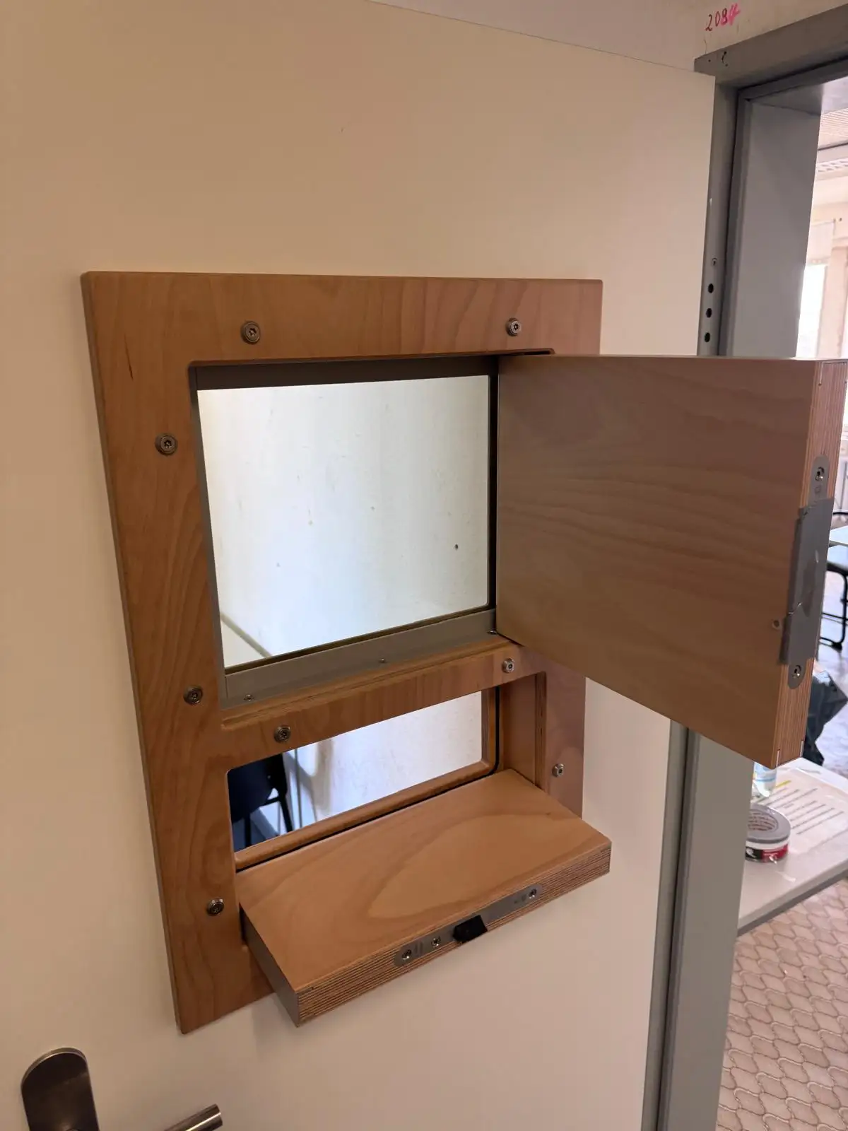 Geöffnete Durchreiche-Klappe mit Blick durch das Sichtfenster der Sicherheitstür